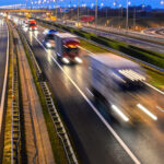 Trucks on a highway in the evening.